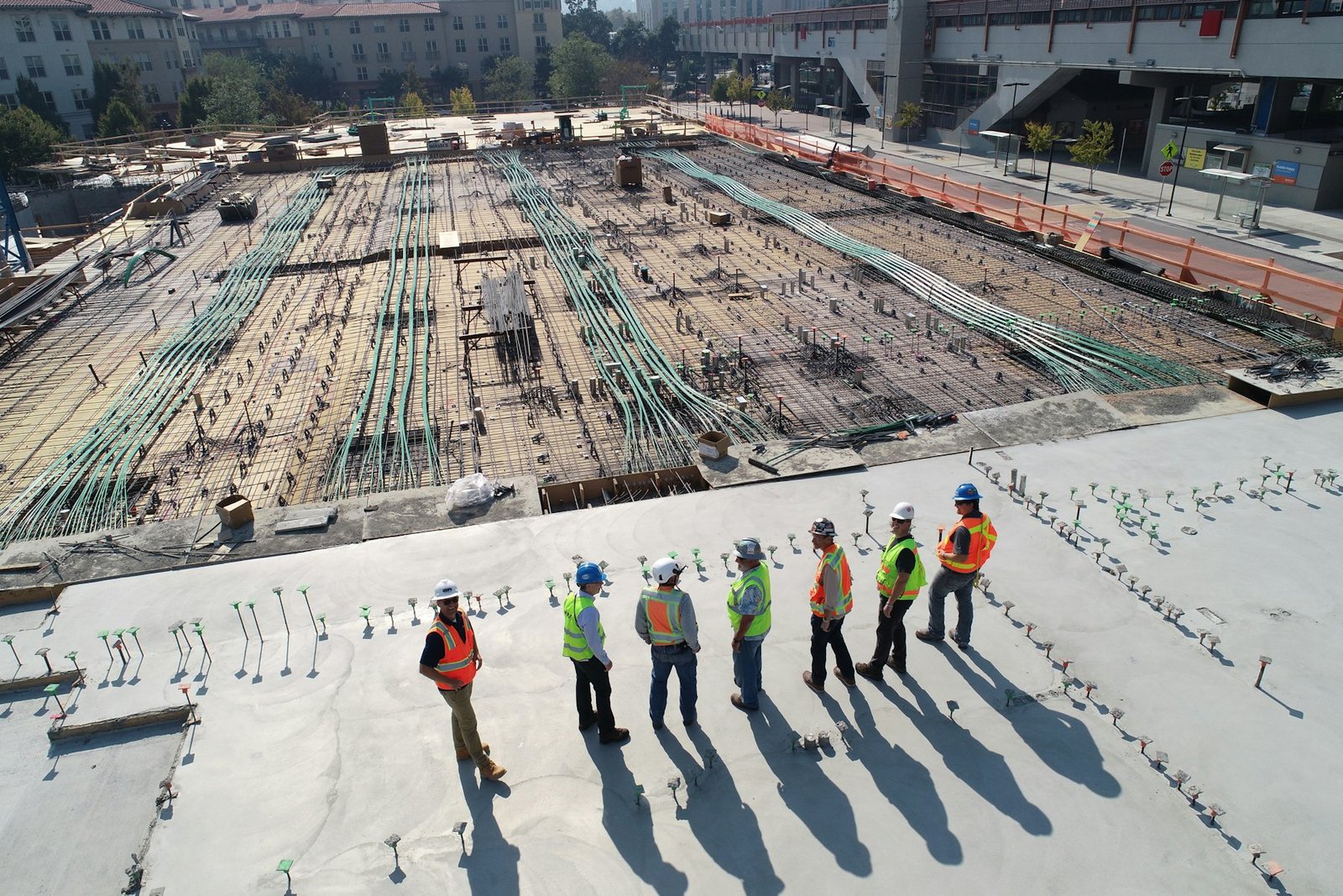Site crew in hard hats and hi-vis vests on a large construction site