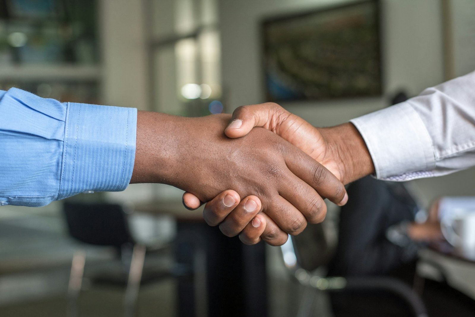 Two people shaking hands to close a contract