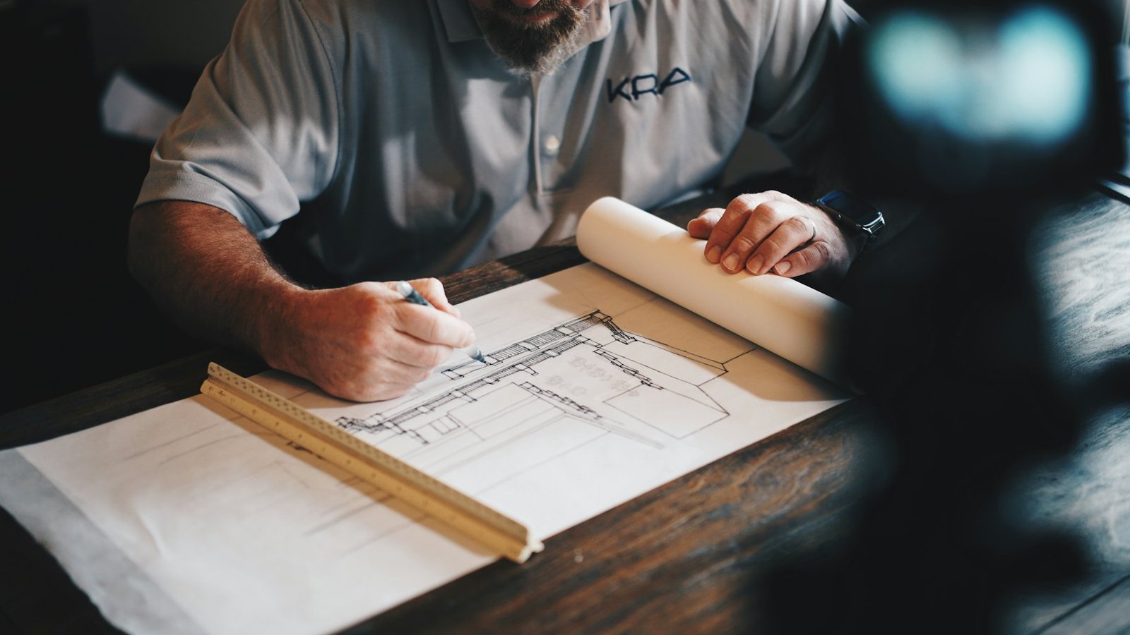 Supervisor checking technical drawings and specifications at a desk